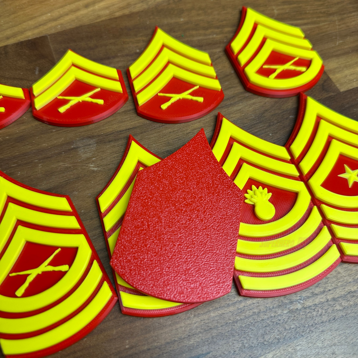 Colorful USMC enlisted rank insignia set featuring red and yellow designs, showcasing multiple Marine Corps ranks.