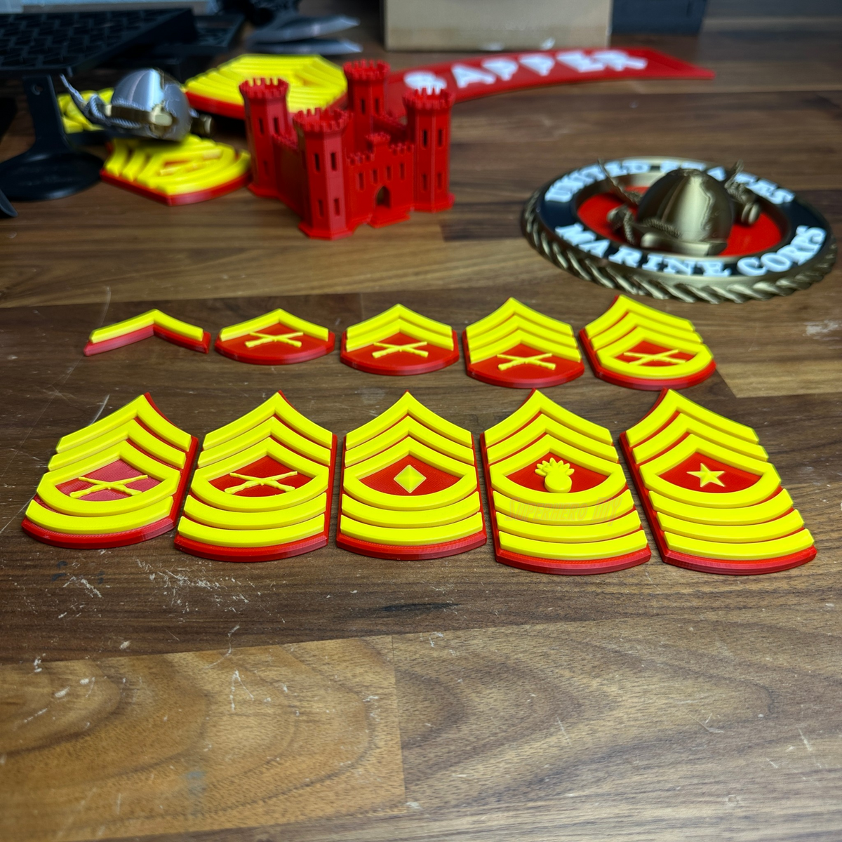 Collection of USMC enlisted rank insignias in red and yellow, showcasing various Marine Corps NCO ranks.