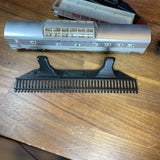 Black HO-scale train display shelf with model train car on wooden table.