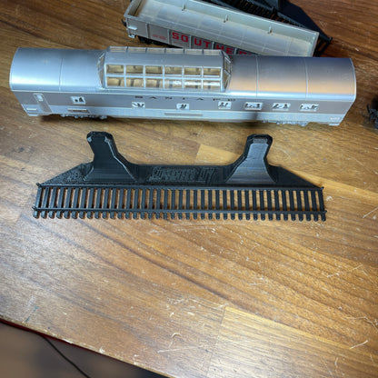 Black HO-scale train display shelf with model train car on wooden table.