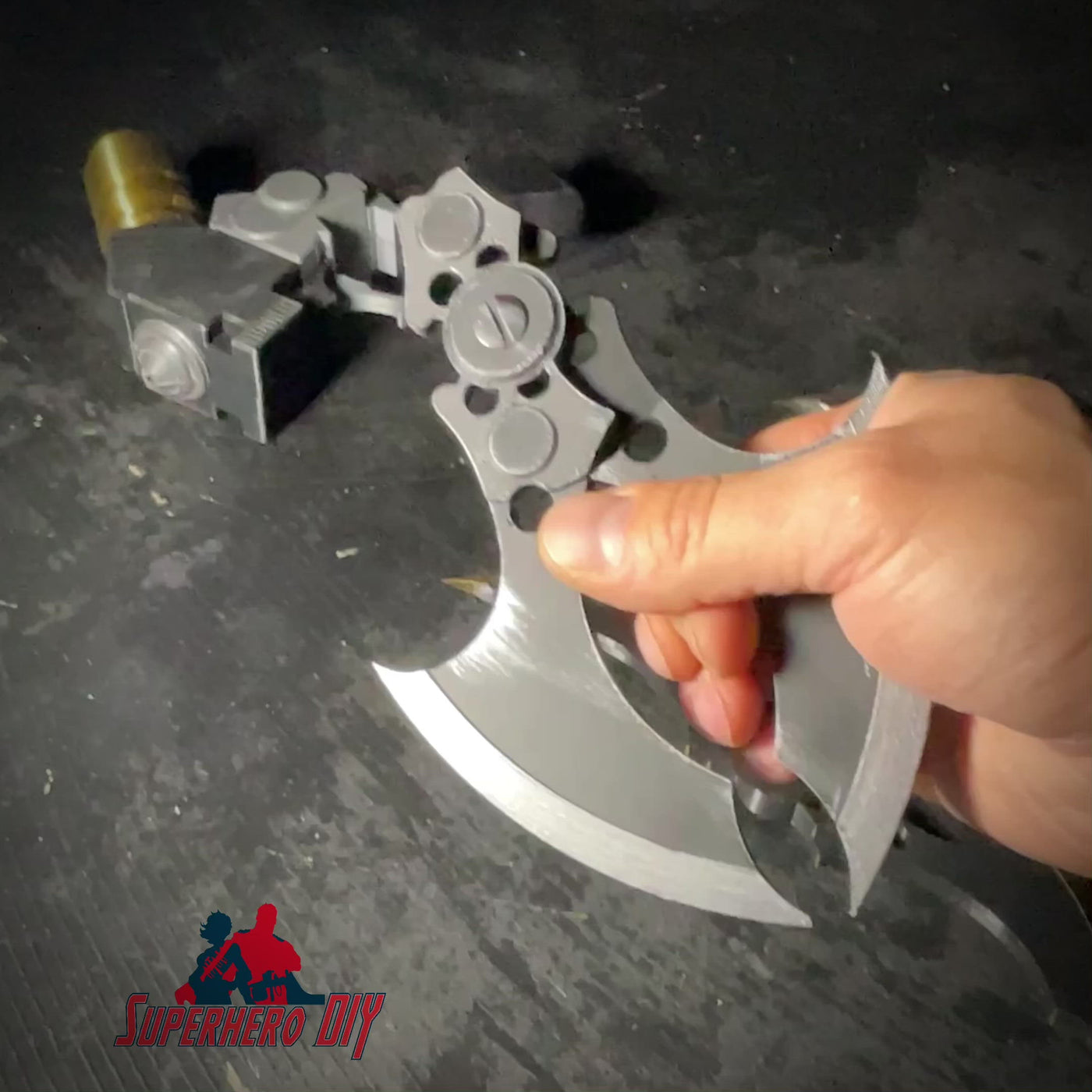 Hand holding MAGNETIC Folding Arkham Batarang Cosplay Prop - 10" version in open position on black surface